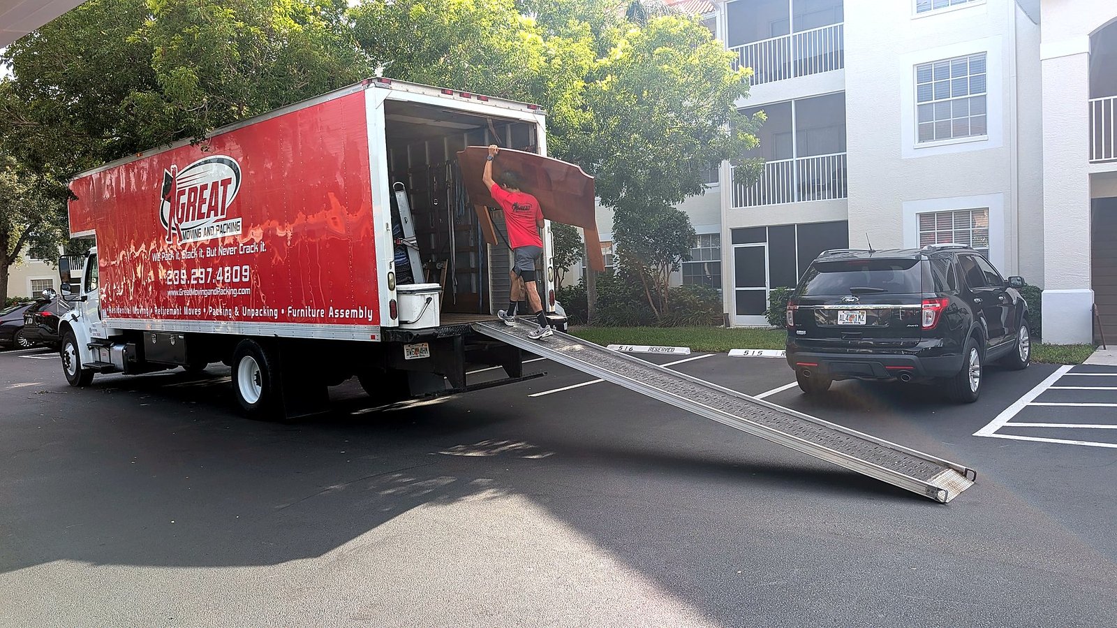 Great Moving & Packing crew loading furniture on the truck ramp at a Southwest Florida condo complex